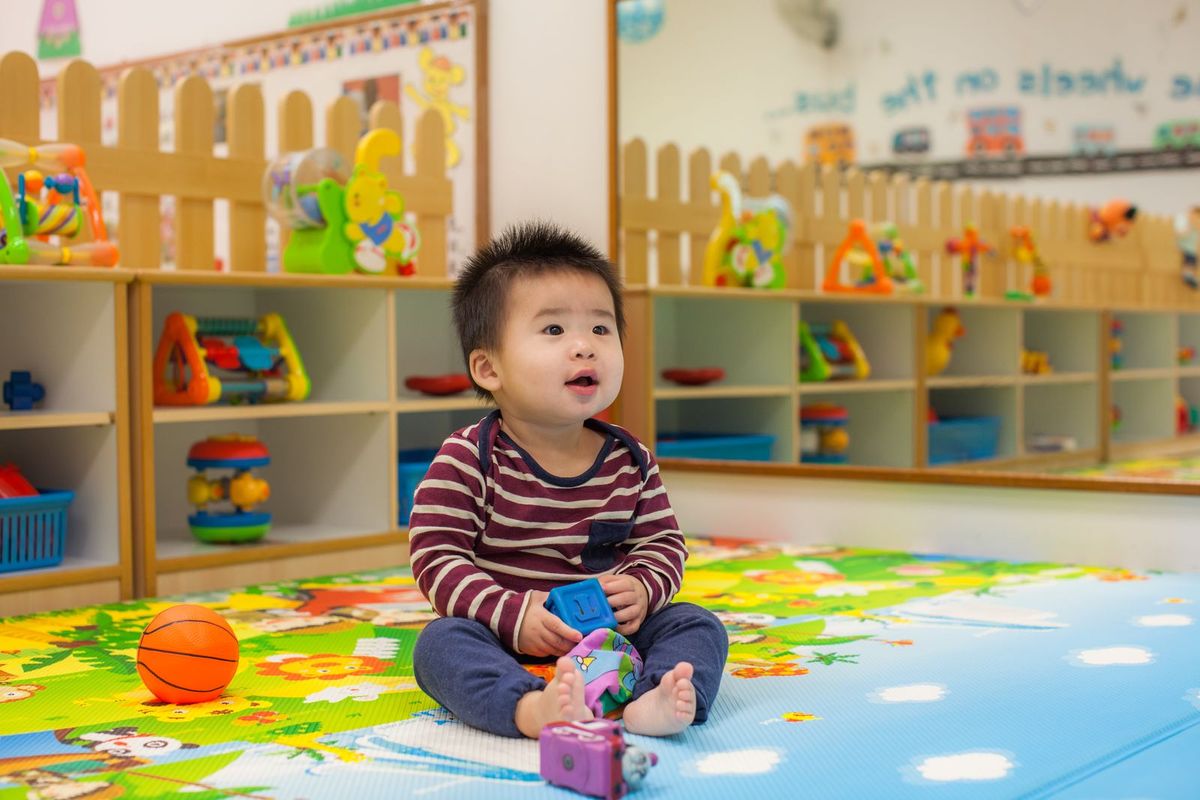 A toddler playing happily in the infant nursery