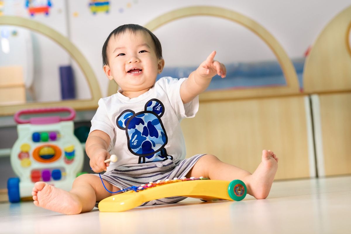 A baby joyfully playing with a musical toy