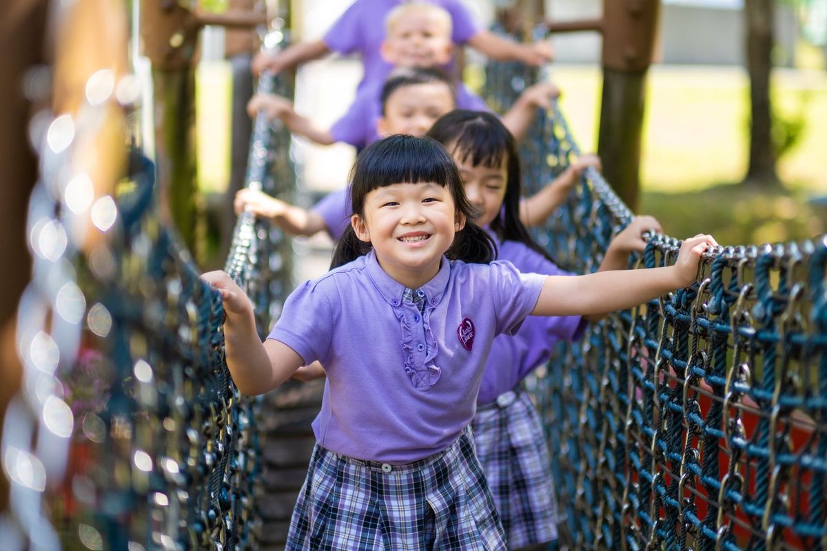Children crossing a rope bridge together on the outdoor playground