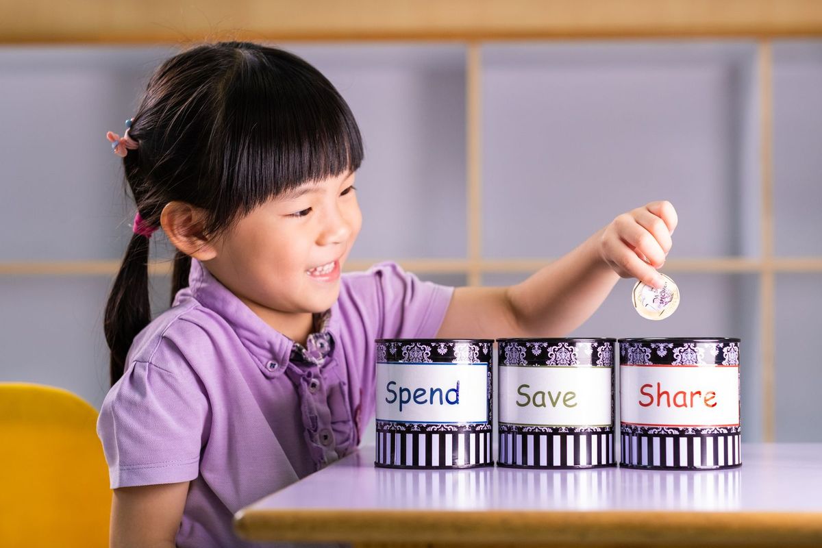 Children practising money-management skills with share, save, spend jars