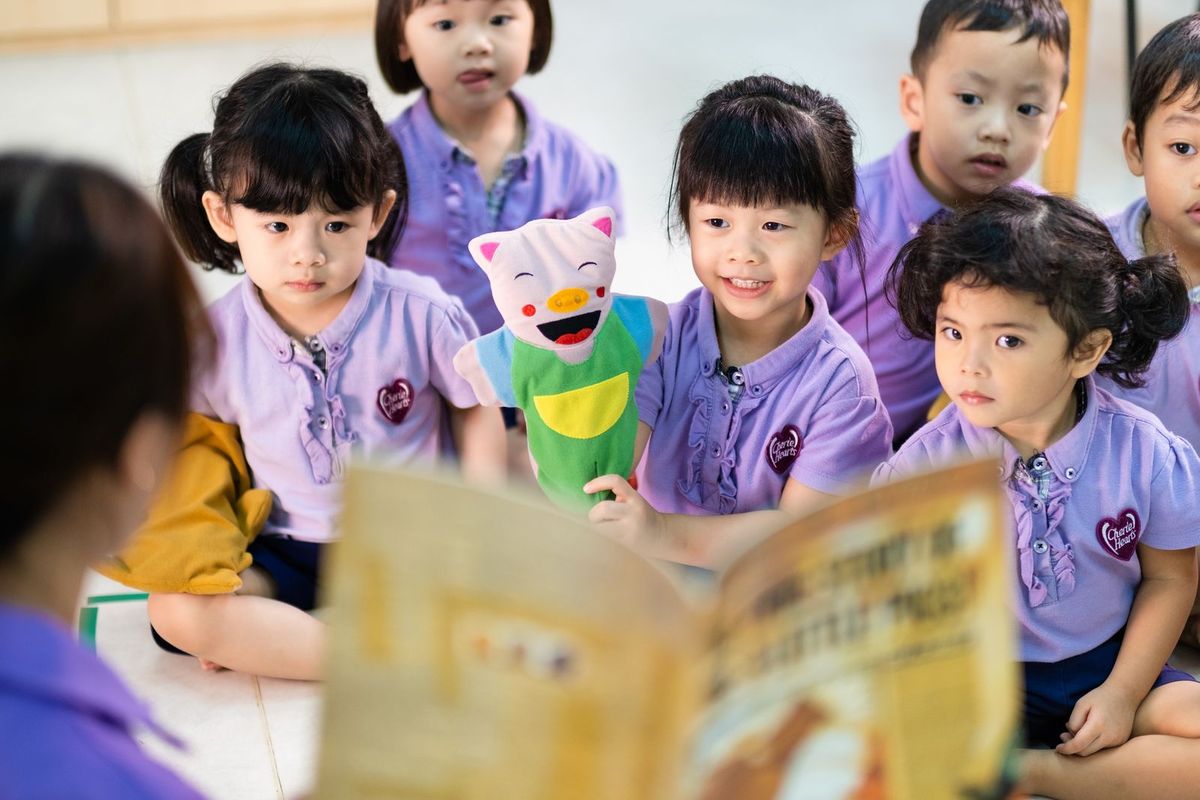 Kindergarten children gathered for storytime with a puppet during a literacy lesson